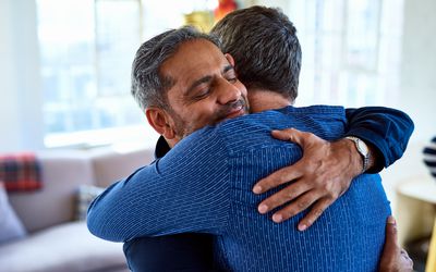 Best friends affectionately embracing, happiness, male bonding, comfort, confidence