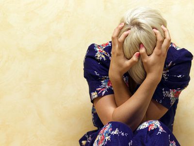 Woman clutching her head in mental anguish