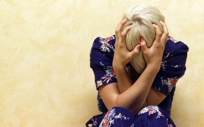 Woman clutching her head in mental anguish