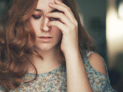 Woman holding her head in pain