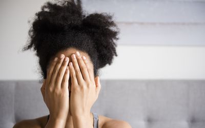 a woman covering face with hands