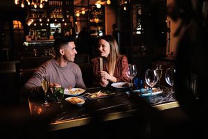 Portrait of young romantic couple on a date at the restaurant. Couple looking at each other and having fun together. 