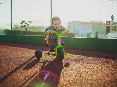 boy playing on tricicle outdoors