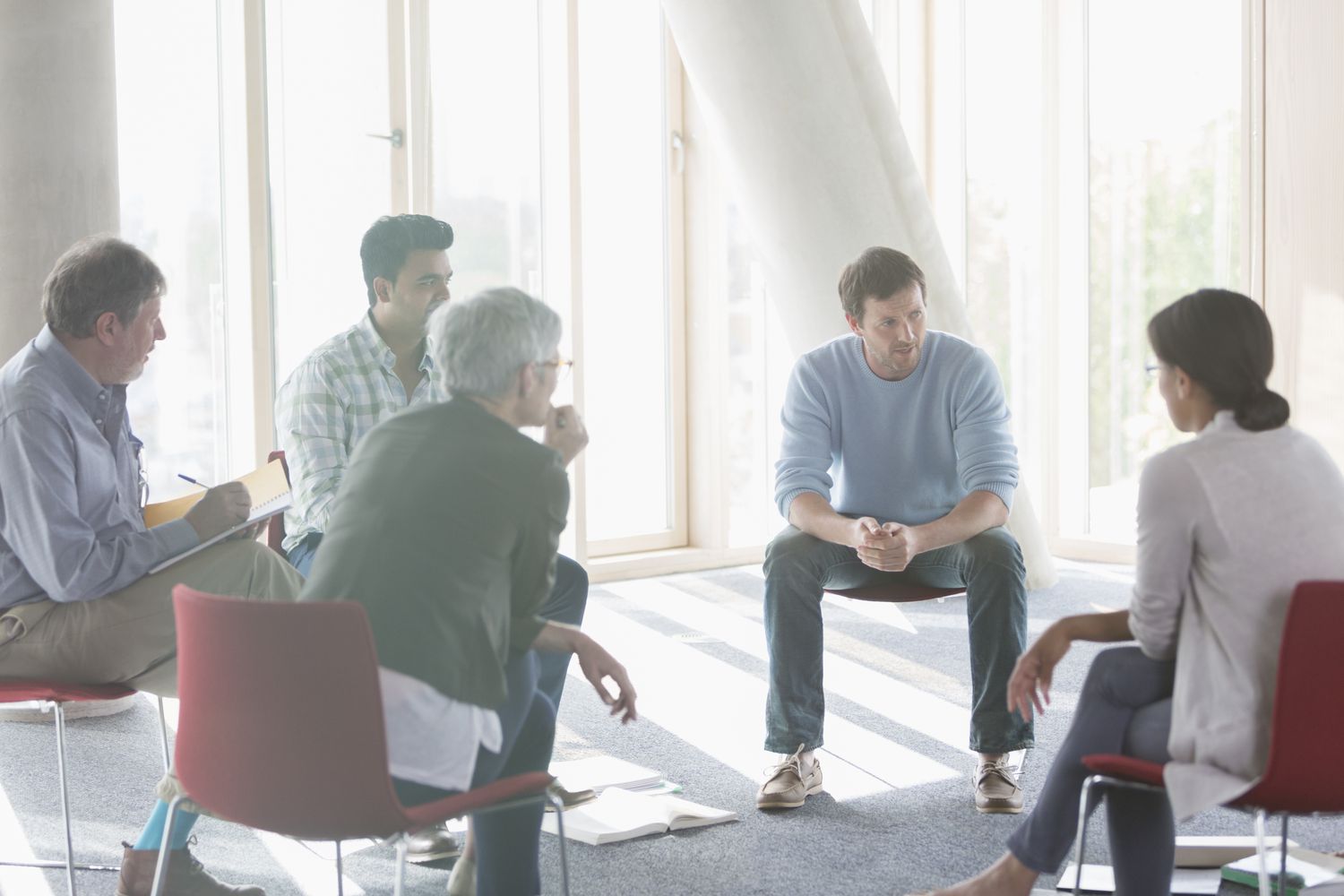 Group of men and women talking in a circle of chairs