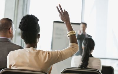 Businesswoman asking question at presentation in office building