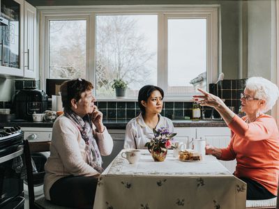 three women sitting at a kitchen