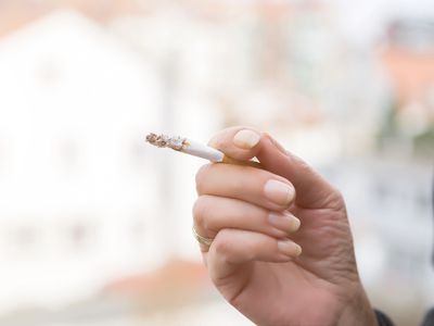 Cropped Hand Of Woman Smoking Cigarette