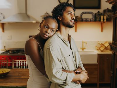 woman hugging her grumpy looking partner