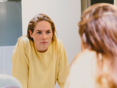 Depressed Teen Looks At Herself in Bathroom Mirror