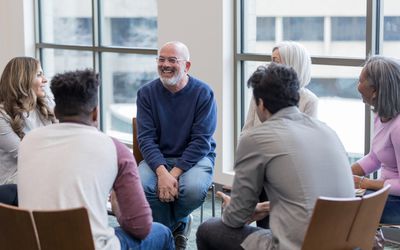 Diverse people sitting in a circle during group therapy