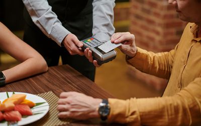 Man paying with credit card for romantic dinner at restaurant