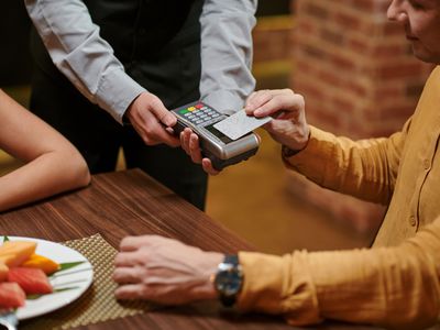 Man paying with credit card for romantic dinner at restaurant