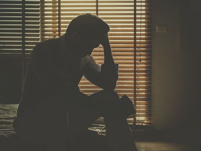 Sad man sitting in dark room