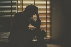 Sad man sitting in dark room