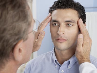 A doctor examines a patient’s eyes.