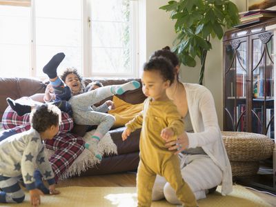 Young family in pajamas playing in living room