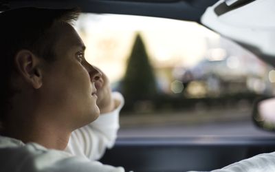 Man driving, lost in thought