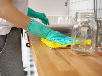 Midsection Of Woman Cleaning Kitchen Counter