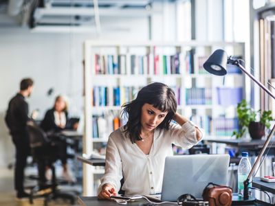 A woman working at her desk in a busy office.