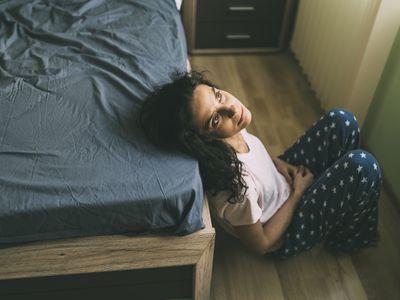 Woman looking at ceiling in bedroom