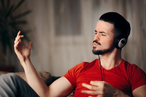 Happy guy listening to music doing air guitar gesture