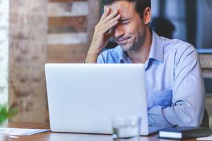 man looking stressed at computer