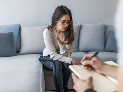 Photo of a therapist writing down notes during therapy with her female patient