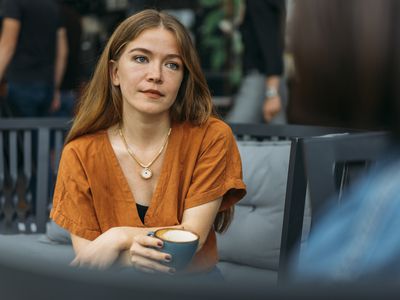 Concerned young woman talks with friend in coffee shop