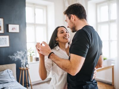 Affectionate young couple in love dancing at home, having fun