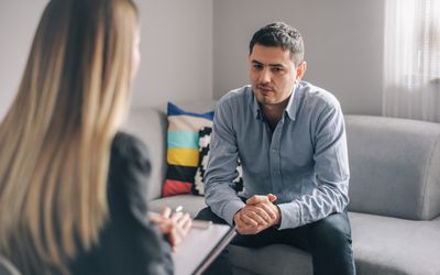 A photography of a man talking to his therapist.