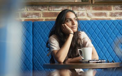 Woman sitting in contemplation at a cafe table