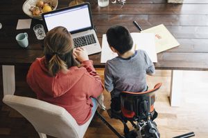 High angle view of mother with autistic son watching video on laptop while sitting at home