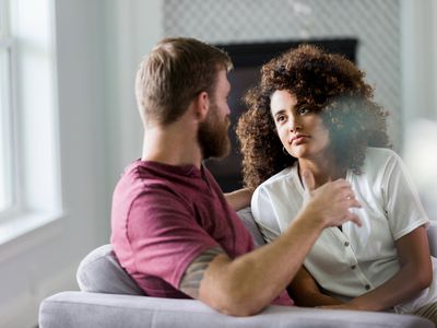 The mid adult woman listens carefully and seriously to her unrecognizable husband as he shares his ideas about their new home.