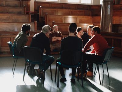 Group of men, seated in therapy session