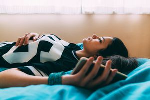 Woman lying on bed feeling depressed.