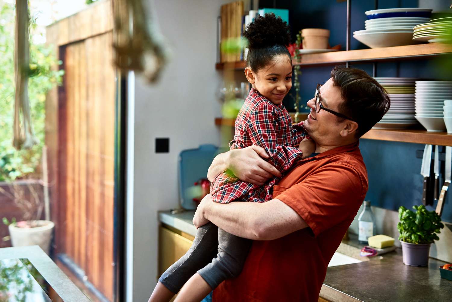 Affectionate father holding young daughter at home, love, family, nurturing