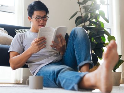 Man sitting down reading a book.