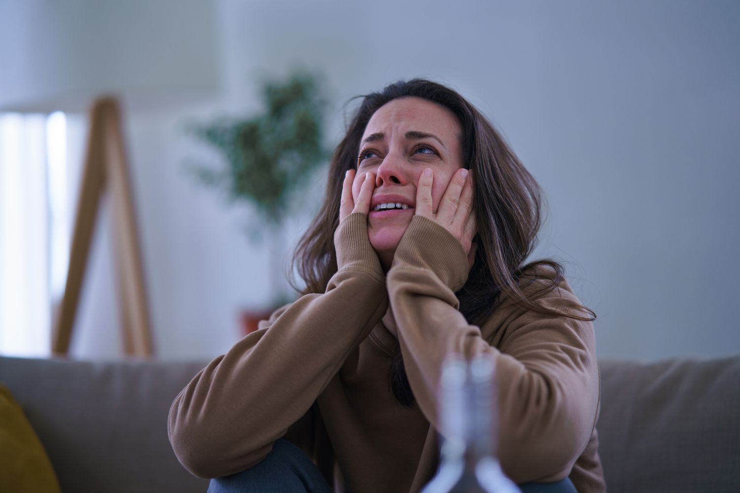 Woman crying with head in hands.