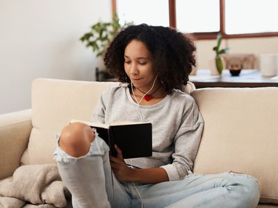 Woman writing in her journal on the couch.