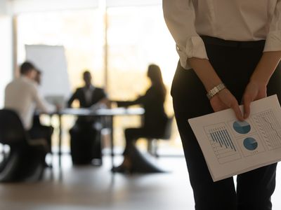 Rear close up view businesswoman holds financial stats papers behind back wait for performance speech feels nervous.