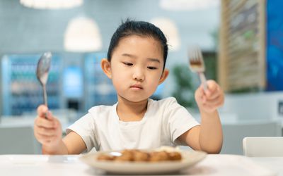 little girl looking at food without appetite