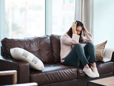 Shot of a young woman experiencing mental anguish at home