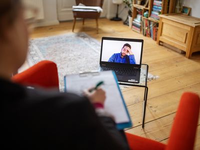 Man having a cognitive behavioral therapy video call with mental health professional