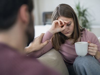 Upset young adults flatmates sitting indoors and talking