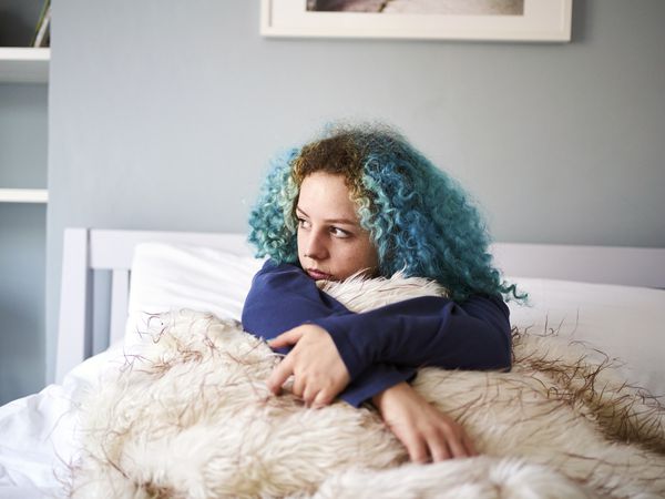 Young woman looking sad depressed and alone in bed