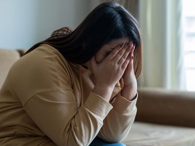 woman looking depressed with head in hands