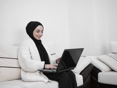  Muslim young woman using laptop at home