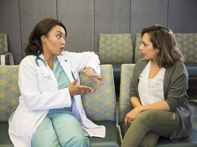 Woman talking to doctor in hospital waiting room