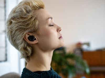 person with their eyes closed, head tilted back, with headphones in listening to music