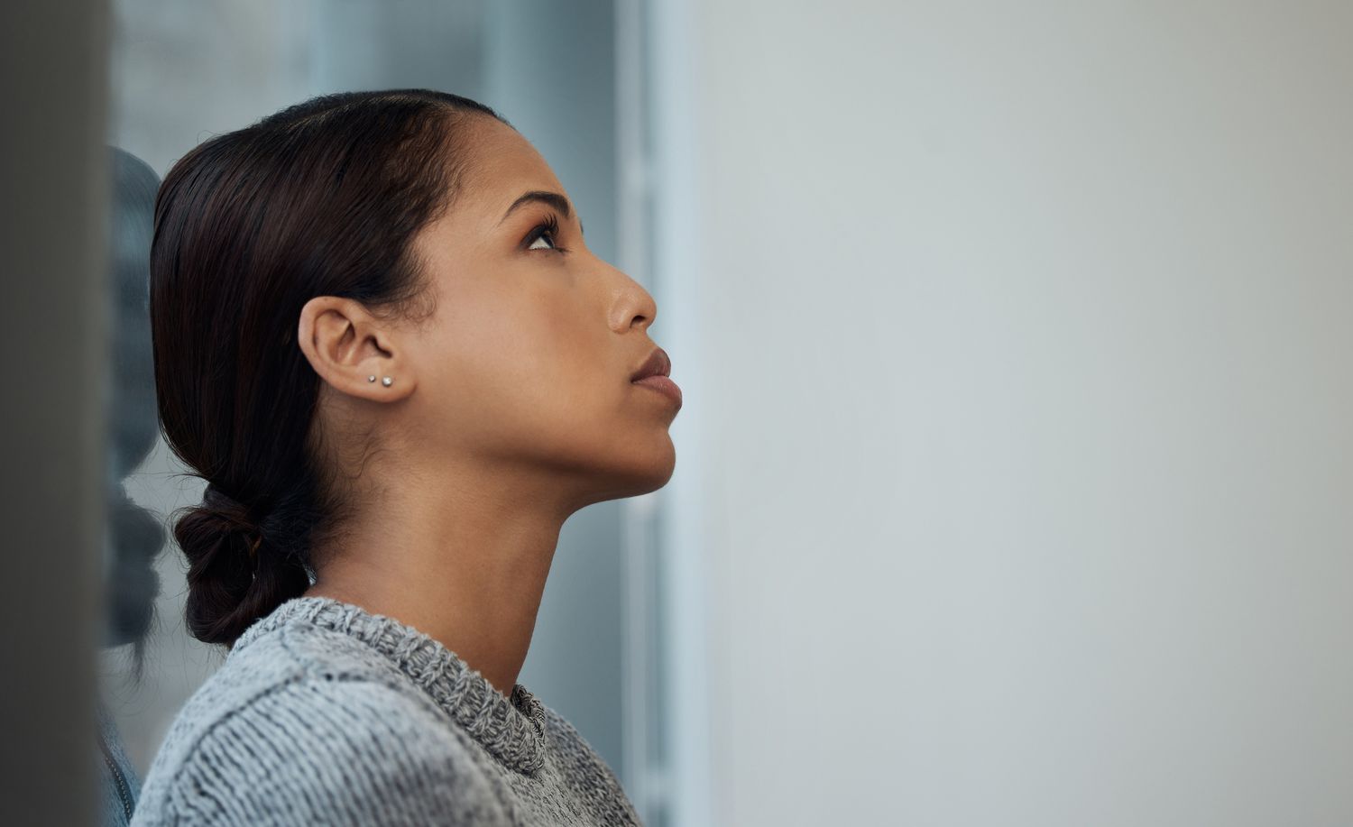 Shot of a young businesswoman taking a break and leaning against a window